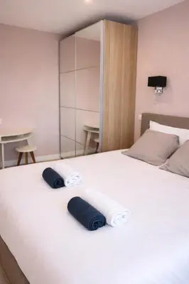 a white bed with two blue pillows on it at Serenity in Cannes
