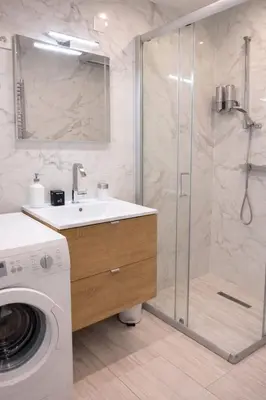 a bathroom with a shower and a sink and a washing machine at Serenity in Cannes