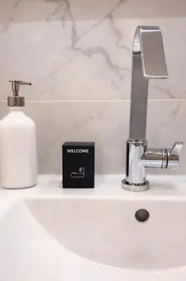 a bathroom sink with a soap dispenser next to a faucet at Serenity in Cannes