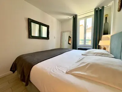 a bedroom with a large bed with a mirror on the wall at Tredici By SCLS Locations in Cannes