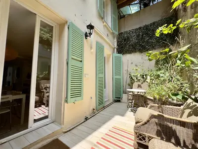 a porch with green shutters and a table and chairs at Tredici By SCLS Locations in Cannes
