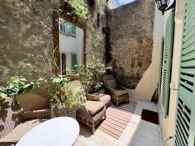 an outdoor patio with chairs and a wall at Tredici By SCLS Locations in Cannes
