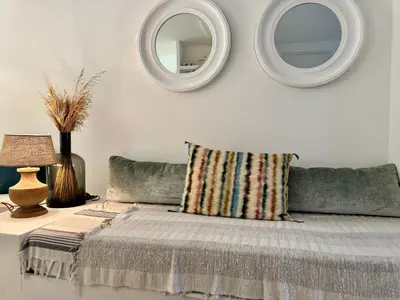 a bed with a pillow and two mirrors on the wall at Tredici By SCLS Locations in Cannes