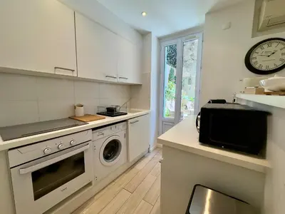 a kitchen with a washing machine and a clock at Tredici By SCLS Locations in Cannes