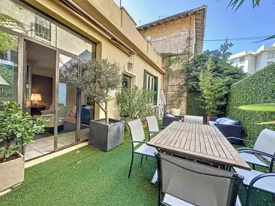 a patio with a table and chairs on the grass at 3-Bedroom house with terrace 5 minutes walking from La Croisette in Cannes