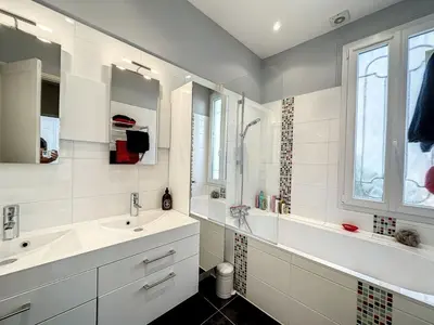 a white bathroom with two sinks and a window at 3-Bedroom house with terrace 5 minutes walking from La Croisette in Cannes
