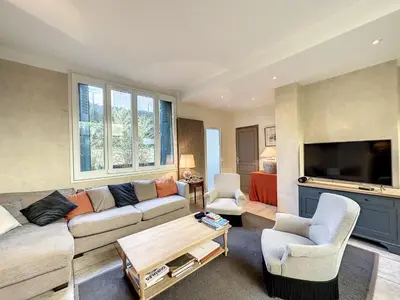 a living room with a couch and a tv at 3-Bedroom house with terrace 5 minutes walking from La Croisette in Cannes