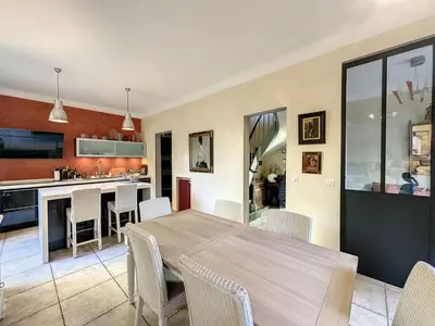a kitchen and dining room with a wooden table and chairs at 3-Bedroom house with terrace 5 minutes walking from La Croisette in Cannes