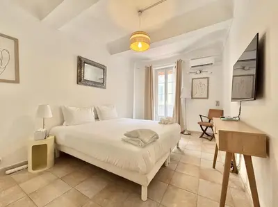 a white bedroom with a bed and a desk at Cannes 2 Bedroom Apartment - 19JDR2 in Cannes