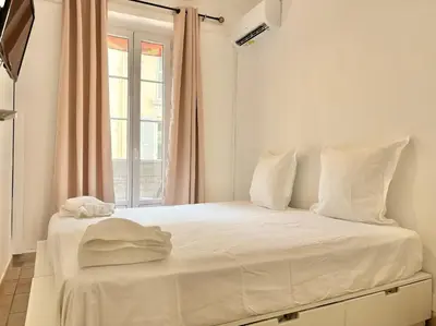 a bedroom with a large white bed with a window at Cannes 2 Bedroom Apartment - 19JDR2 in Cannes