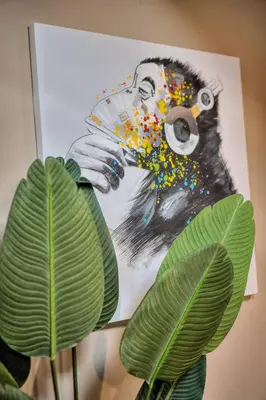 a picture of a monkey with a camera and a plant at Studio Cannes in Cannes