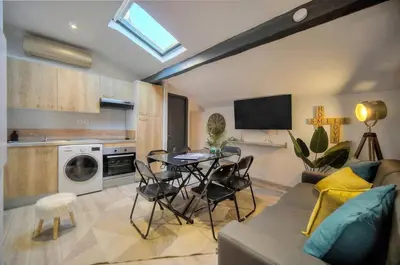 a living room with a table and chairs and a kitchen at Le 8 - Cannes in Cannes