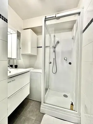 a white bathroom with a shower and a sink at Cannes 1 Bedroom Apartment - CC1 in Cannes