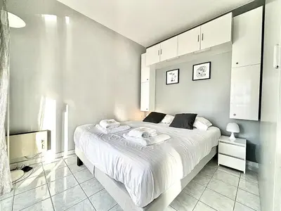 a white bedroom with a large bed with towels on it at Cannes 1 Bedroom Apartment - CC1 in Cannes