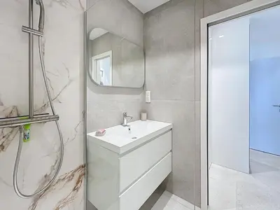 a white bathroom with a sink and a shower at 39m2 Croisette, terrasse, vue mer, garage in Cannes