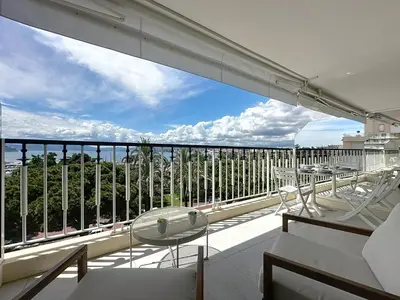 a balcony with tables and chairs on a building at 39m2 Croisette, terrasse, vue mer, garage in Cannes