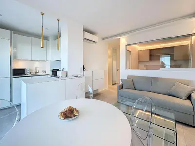 a living room with a white table and a couch at 39m2 Croisette, terrasse, vue mer, garage in Cannes