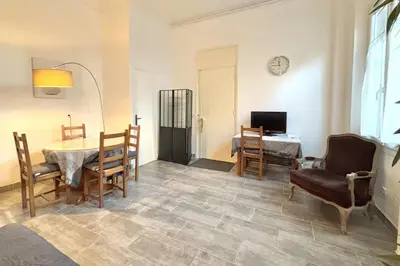 a living room with a table and chairs and a television at Luminous T2 on the seafront in Cannes