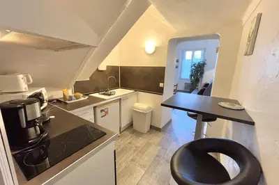 a kitchen with a black chair in the middle of it at Luminous T2 on the seafront in Cannes