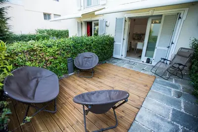 two chairs and two tables on a wooden deck at Résidence Les Palmiers by Connexion in Cannes
