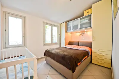 a small bedroom with a bed and a crib at Résidence Les Palmiers by Connexion in Cannes