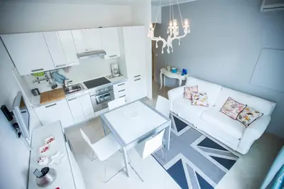 a living room with a white couch and a table at Résidence Les Palmiers by Connexion in Cannes