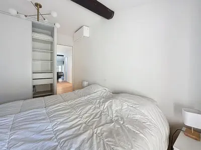 a white bedroom with a bed and a closet at 54m2 hypercenter, face Palais des Festivals in Cannes