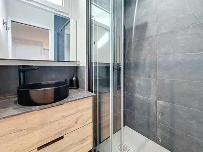 a bathroom with a sink and a glass shower at 54m2 hypercenter, face Palais des Festivals in Cannes