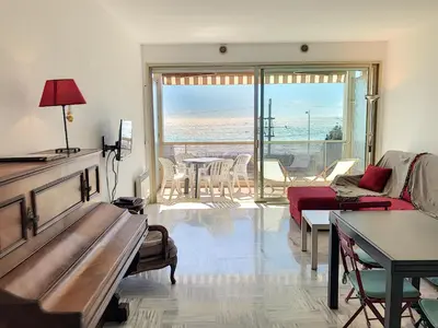 a living room with a couch and a table at Bord de mer, terrasse vue mer 228L in Cannes