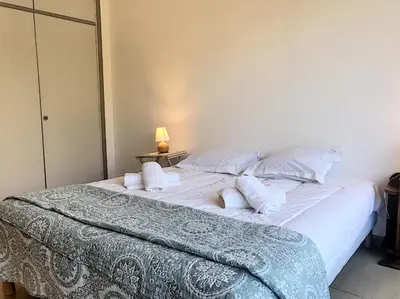a bedroom with a large bed with white sheets and pillows at Bord de mer, terrasse vue mer 228L in Cannes