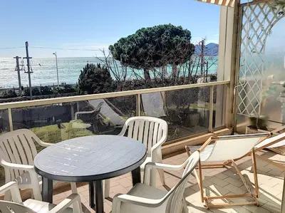 a table and chairs on a balcony with a view of the ocean at Bord de mer, terrasse vue mer 228L in Cannes