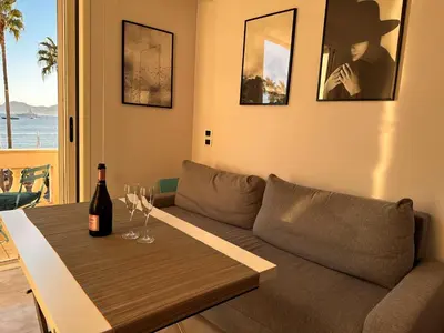 a living room with a couch and a table with wine glasses at Residence Palais Miramar in Cannes