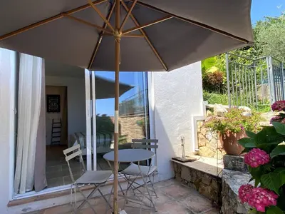 an umbrella on a patio with a table and chairs at Kathleen CANNES-GOLFE JUAN in Vallauris