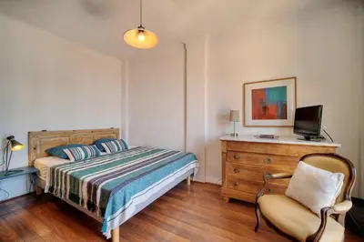a bedroom with a bed and a chair and a television at Kathleen CANNES-GOLFE JUAN in Vallauris