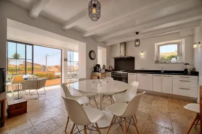 a kitchen with a table and chairs and a kitchen with a window at Kathleen CANNES-GOLFE JUAN in Vallauris