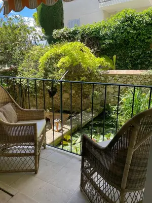 a balcony with two chairs and a view of a garden at Architect's house 100m2 sea view, terraces 35m2 in Le Cannet