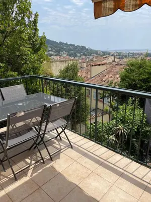 a balcony with a table and a view of a city at Architect's house 100m2 sea view, terraces 35m2 in Le Cannet