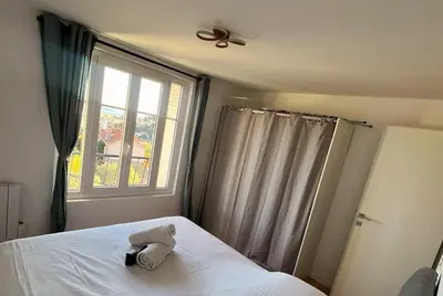 a stuffed animal on a bed in a bedroom with a window at 3 pièces cocon dans les hauteurs de Cannes vue mer in Le Cannet