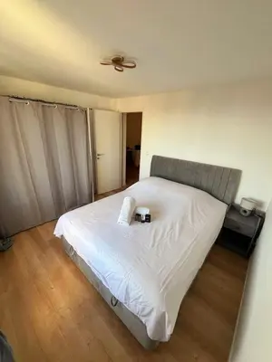 a bedroom with a bed with white sheets and a ceiling at 3 pièces cocon dans les hauteurs de Cannes vue mer in Le Cannet