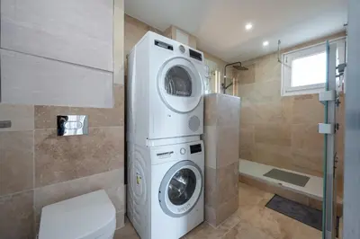 a bathroom with a washing machine and a toilet at 3 pièces cocon dans les hauteurs de Cannes vue mer in Le Cannet
