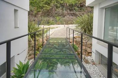 a balcony with a glass walkway leading down to a path at FRGK 