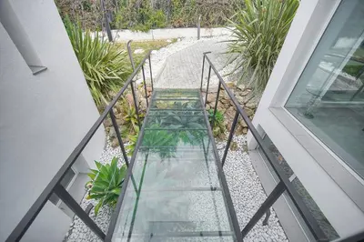 a glass walkway leading to a balcony with plants at FRGK 