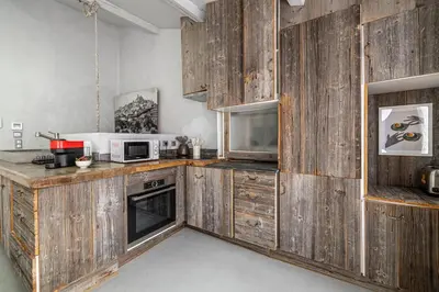a kitchen with wooden cabinets and a microwave at Croisette Cannes duplex in Cannes