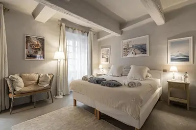 a bedroom with a large bed and a chair at Croisette Cannes duplex in Cannes