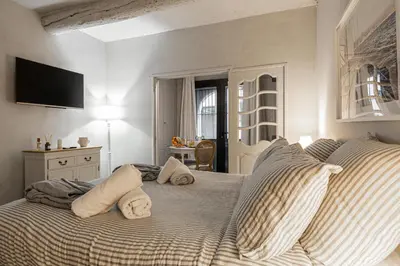 a bedroom with a bed with pillows and a television at Hotel particulier Croisette in Cannes