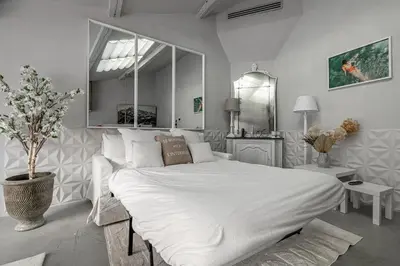 a bedroom with a large white bed with a large mirror at Hotel particulier Croisette in Cannes
