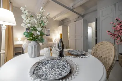 a white table with a bottle of wine and a vase at Hotel particulier Croisette in Cannes