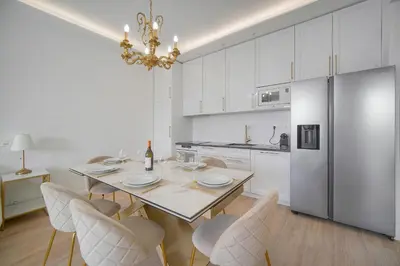 a white kitchen with a dining table and chairs at Luxueux 3 chambres BALCON, CARRE D'OR- COEUR DE CANNES A3B129 in Cannes