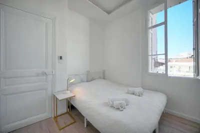 a white bedroom with a bed and a window at Luxueux 3 chambres BALCON, CARRE D'OR- COEUR DE CANNES A3B129 in Cannes