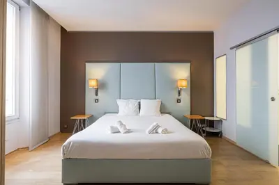 a bedroom with a large bed with two towels on it at LE SAINT HONORÉ idéalement situé au cœur de Cannes in Cannes